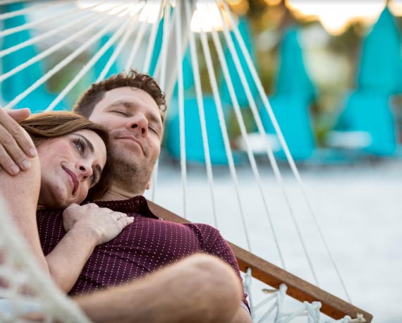 Couple relaxing on a hammock at Fins Up Beach Club